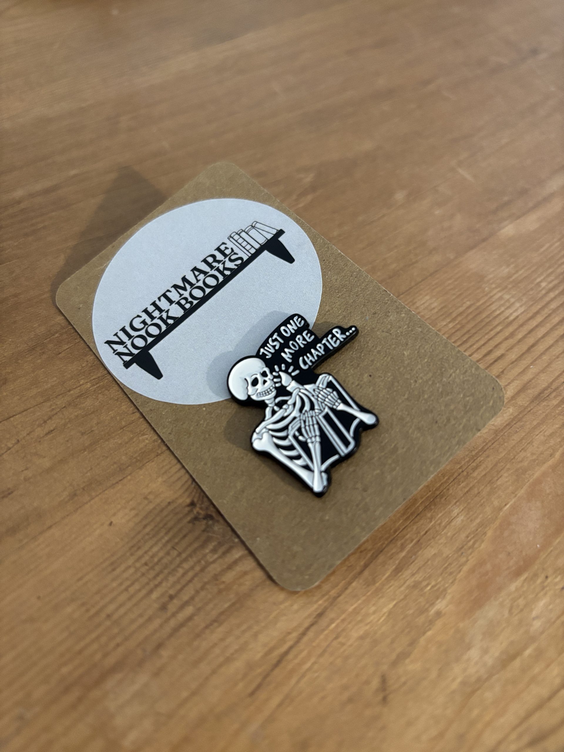 Just One More Chapter Skeleton Enamel Pin on backing card